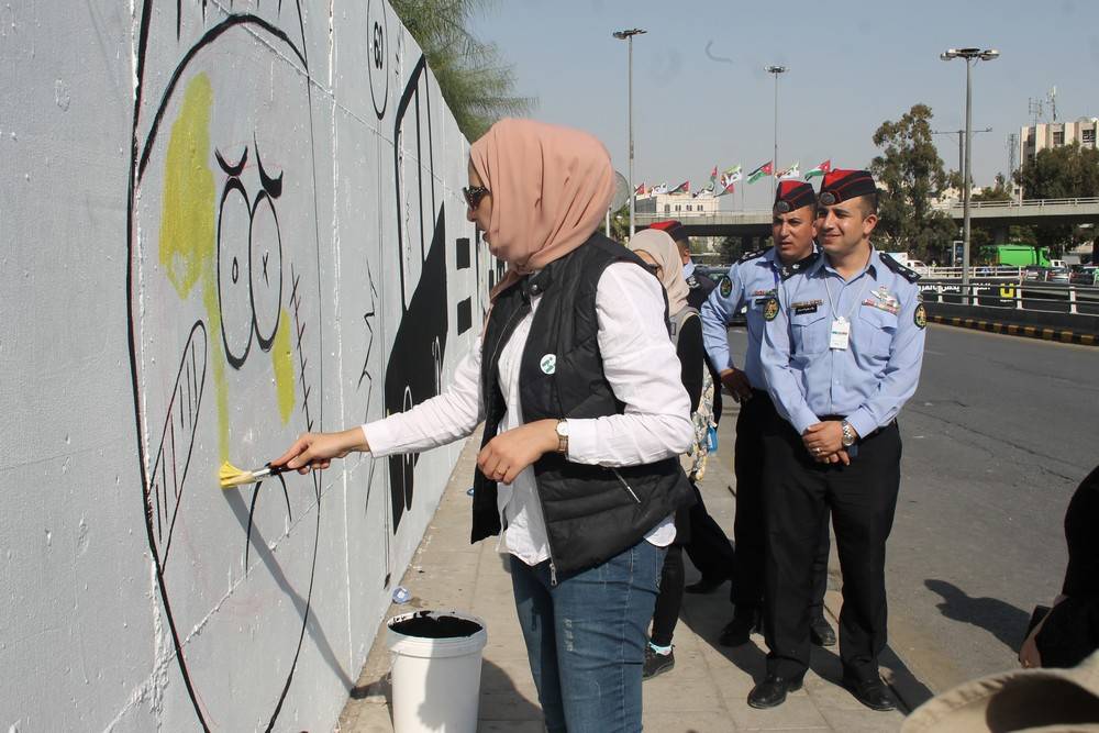 الشرطة المُجتمعية تُنفِذ جِدارية لاتكتُب وأنت سايق  قُرب دوار الداخلية