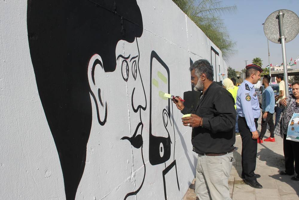 الشرطة المُجتمعية تُنفِذ جِدارية لاتكتُب وأنت سايق  قُرب دوار الداخلية