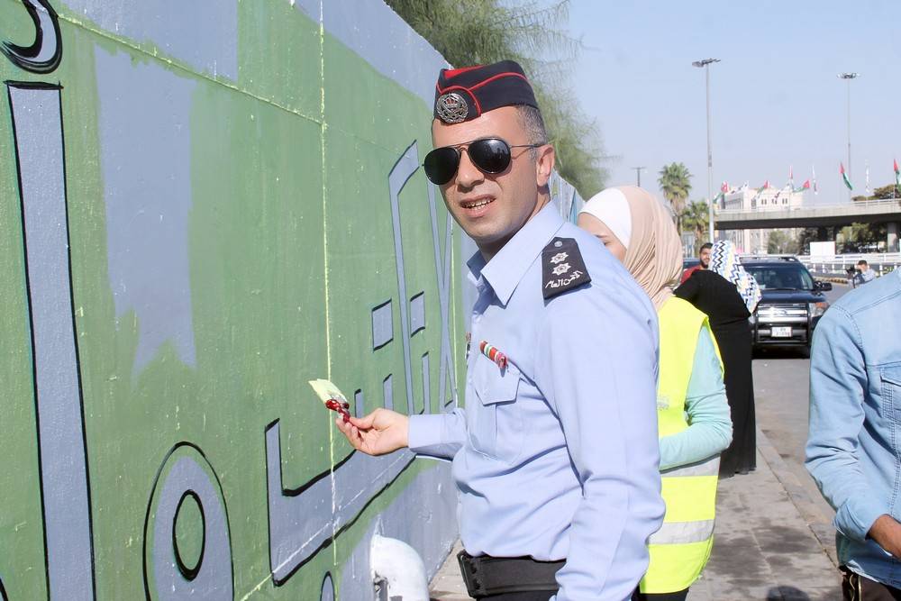 الشرطة المُجتمعية تُنفِذ جِدارية لاتكتُب وأنت سايق  قُرب دوار الداخلية