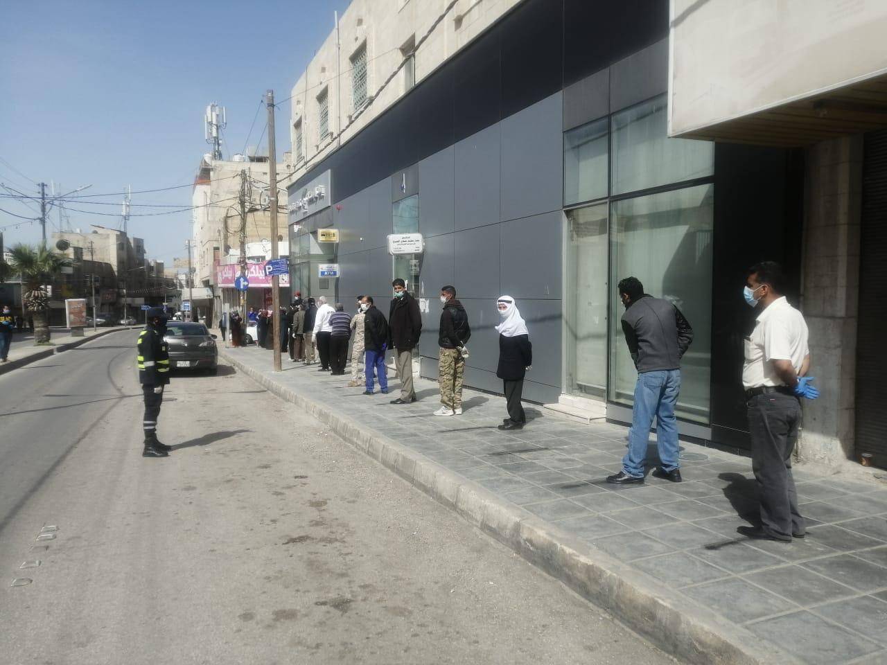 رجال الامن العام ينظمون الاصطفاف والدور امام فروع البنوك .. صور
