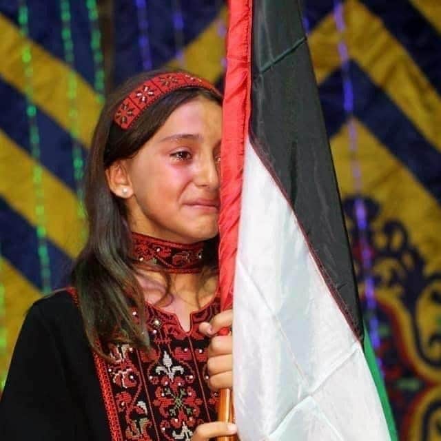 الطفلة سلوى شعث تخفي دموعها بالعلم الفلسطيني .. فيديو وصور