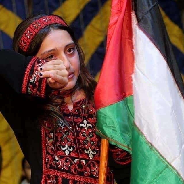 الطفلة سلوى شعث تخفي دموعها بالعلم الفلسطيني .. فيديو وصور