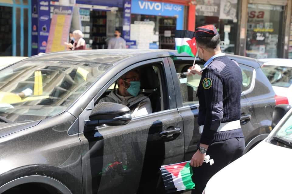نشامى ونشميات الأمن العام يهدون علم الوطن للمارة والمركبات .. صور 