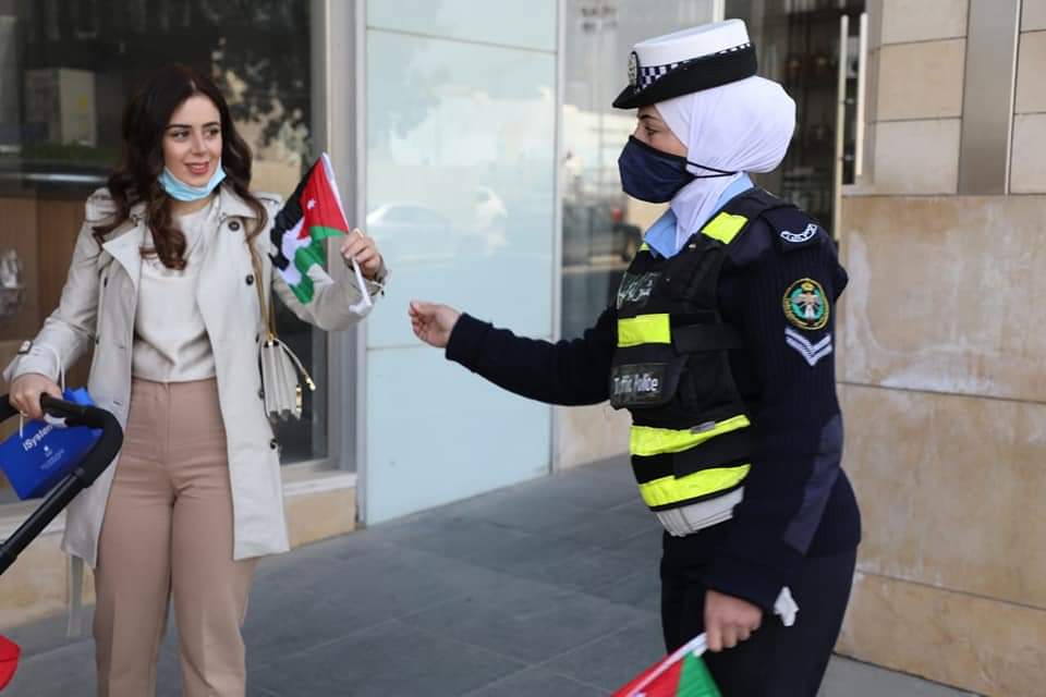 نشامى ونشميات الأمن العام يهدون علم الوطن للمارة والمركبات .. صور 