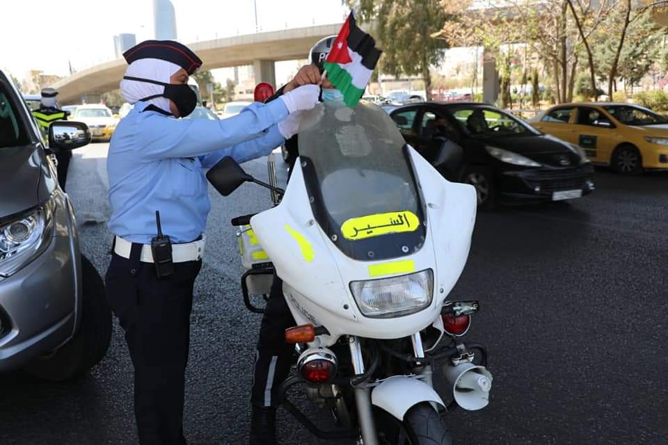 نشامى ونشميات الأمن العام يهدون علم الوطن للمارة والمركبات .. صور 