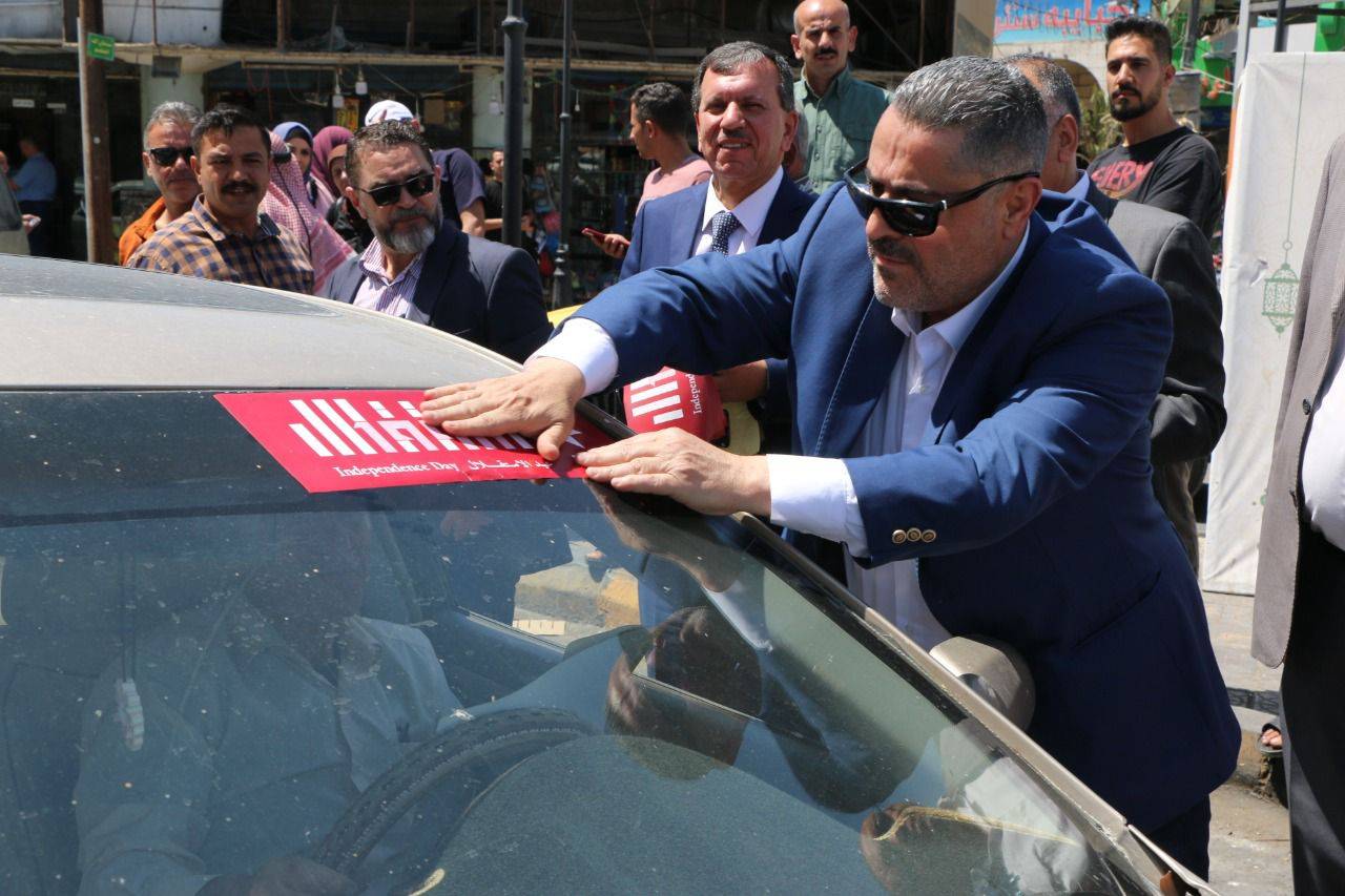 بحضور المحافظ الجبور .. بلدية الزرقاء تنفذ مبادرة لتوزيع شعار الاستقلال وصور الملك واعلام الاردن 